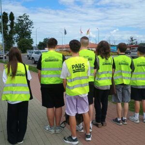 pamiątkowe zdjęcie grupowe studentów w kamizelkach odblaskowych z nazwą uczelni i kierunku studiów