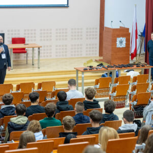 uczniowie w uczelnianej Auli, na środku wykładowcy PANS
